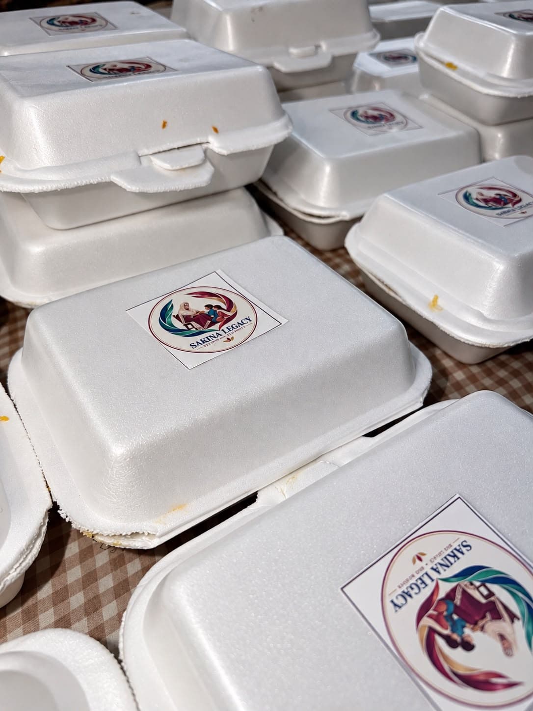 Sealed meal boxes, each carrying the Sakina Legacy emblem