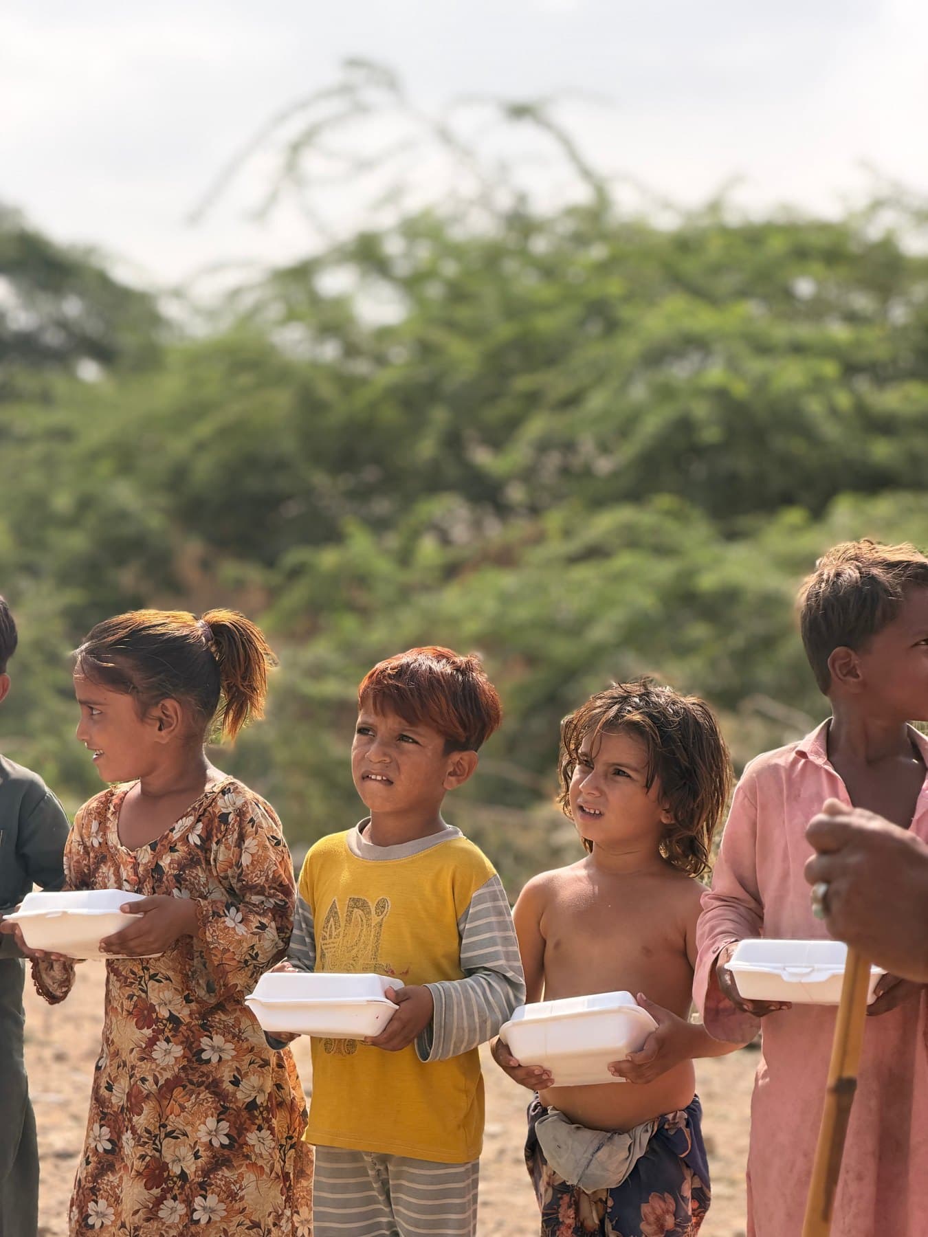 Children holding the meal boxes they received during the 7 October distribution